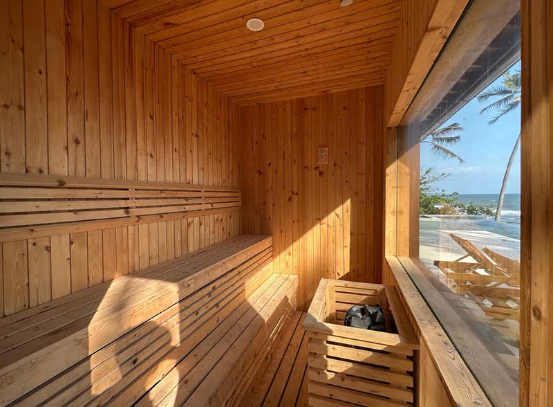 Sauna interior with ocean view window and heater, Bali